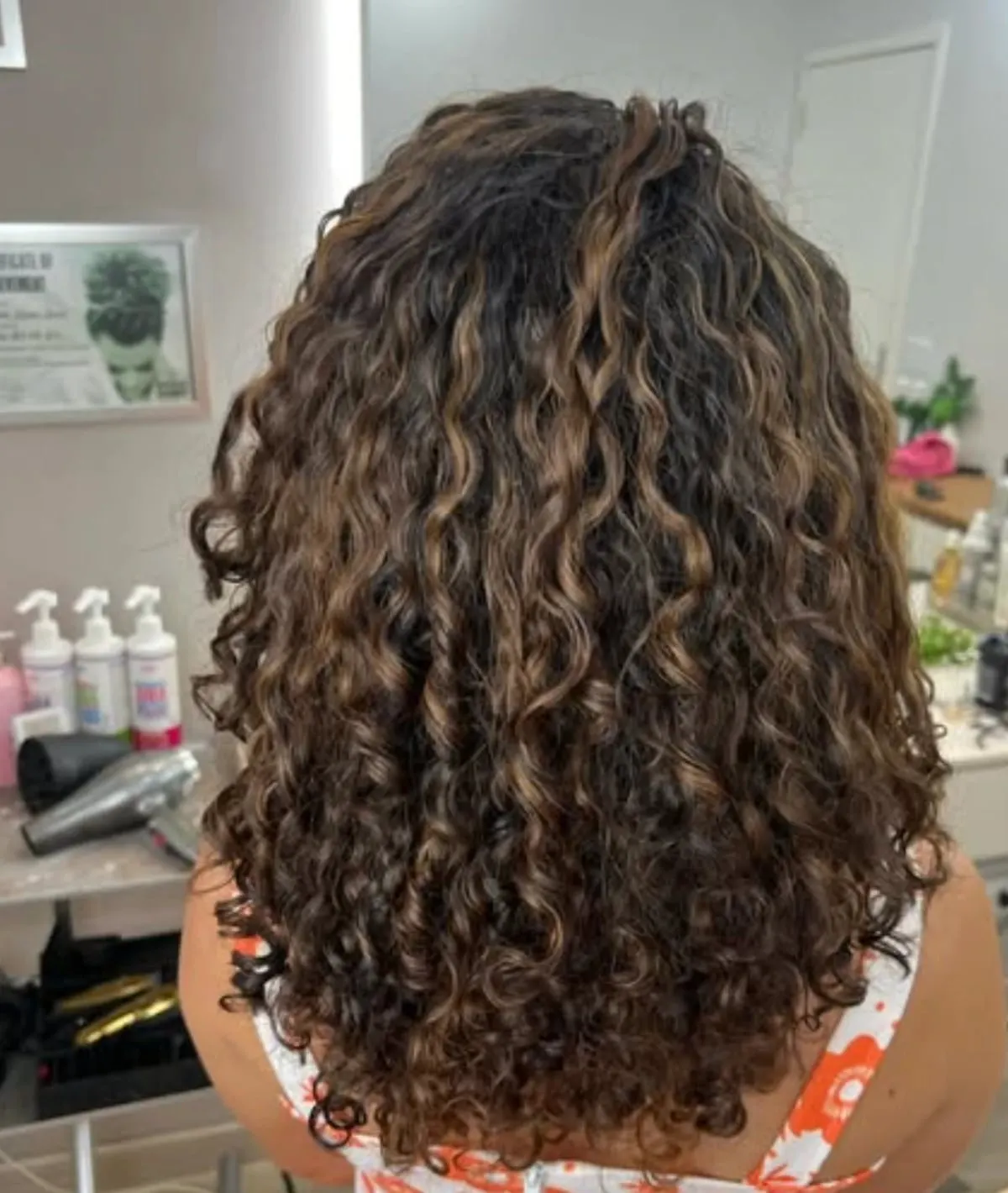Cachos castanhos com mechas iluminadas, comprimento até o meio das costas